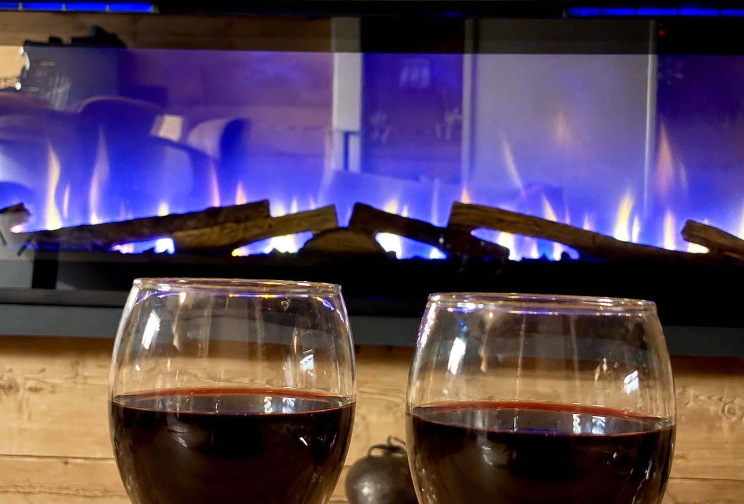 Gros plan sur la cheminée d'ambiance, flammes et verres de vin — soirée d'hiver au studio, Les Contamines-Montjoie